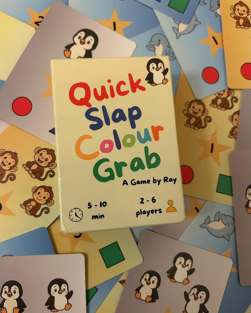 Quick Slap Colour Grab game box on a spread of colourful cards